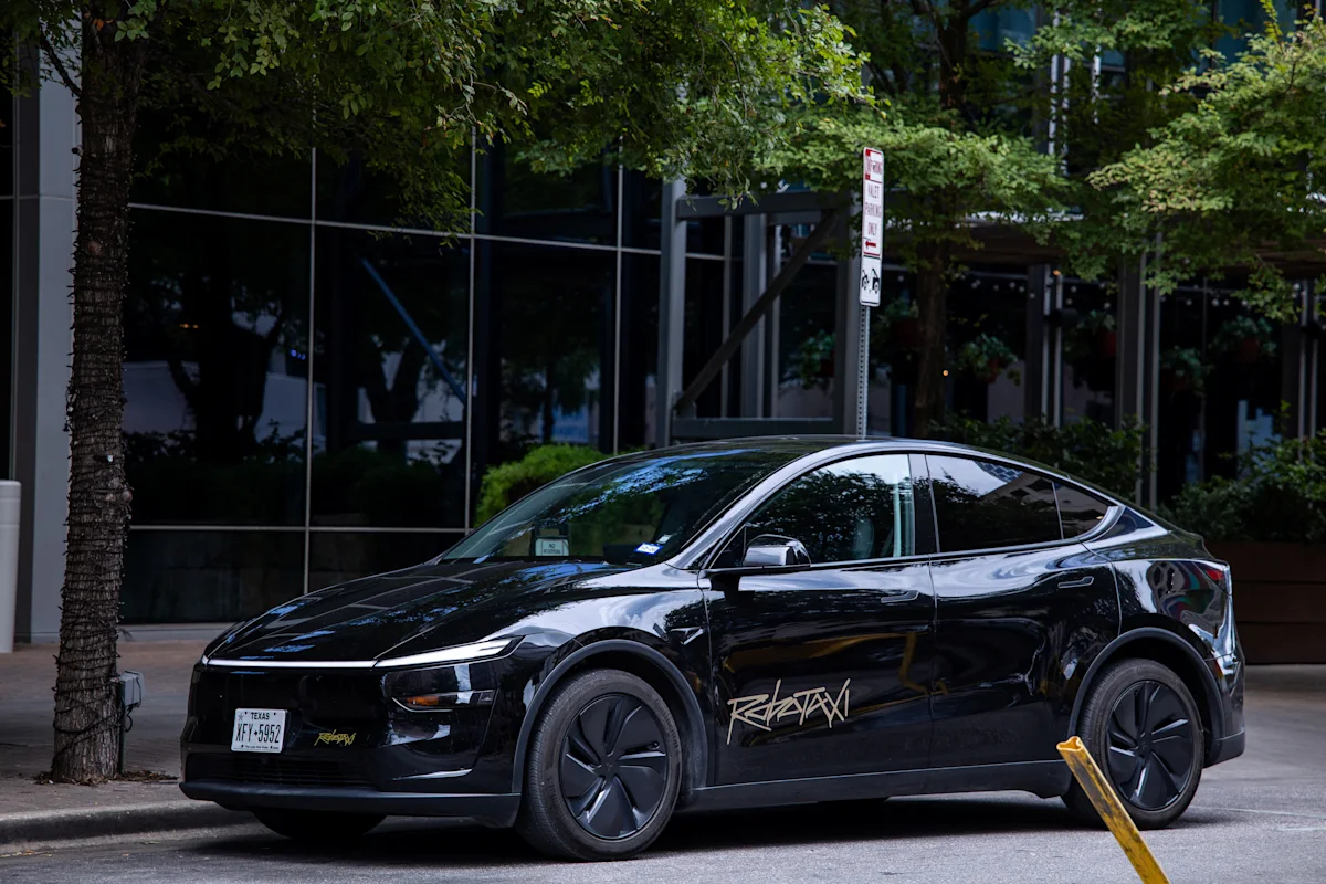 Mobil listrik Tesla melaju di jalan raya dengan latar belakang gedung perkotaan